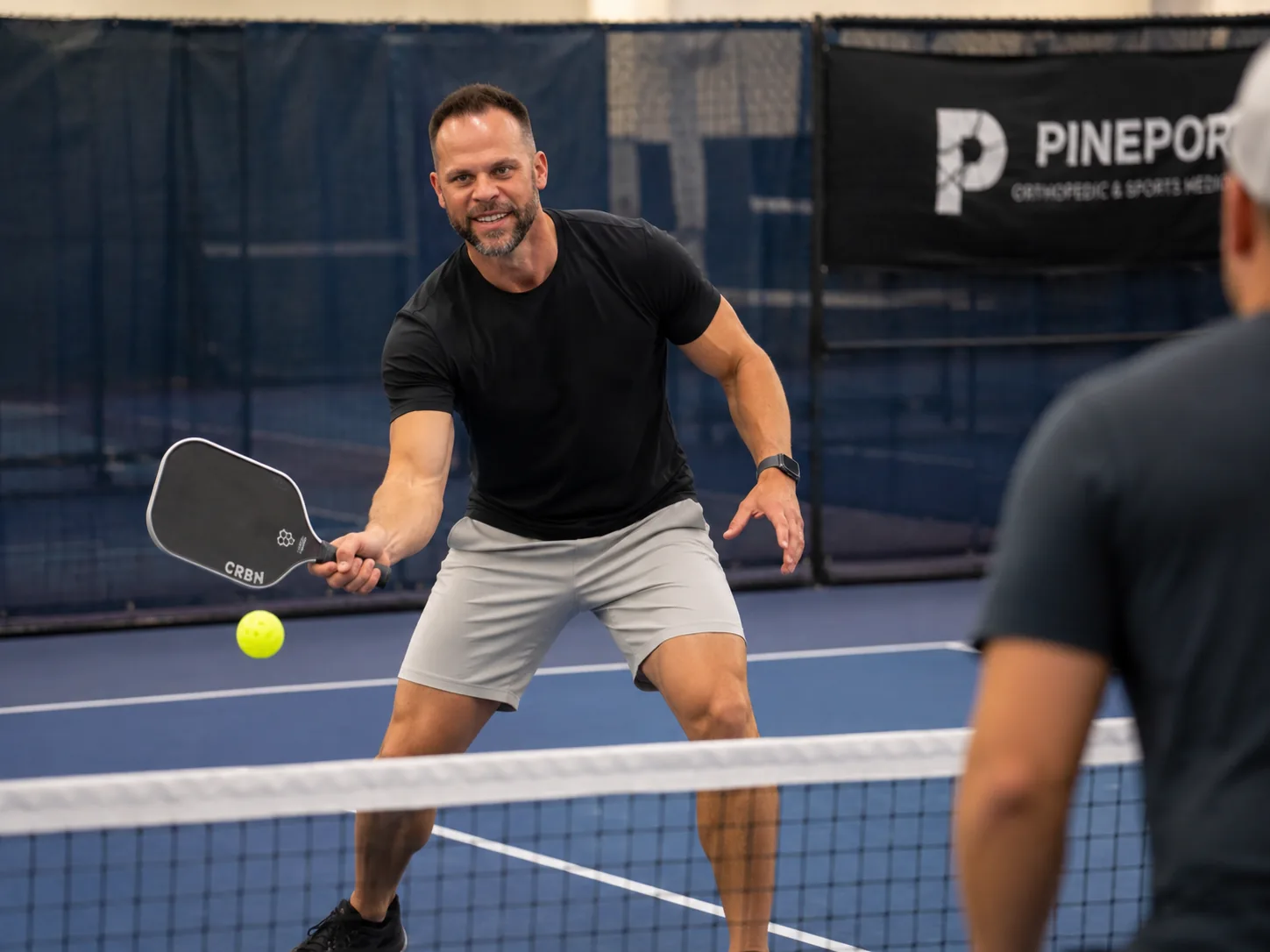 Dr. Joseph Krzemien playing pickleball on court