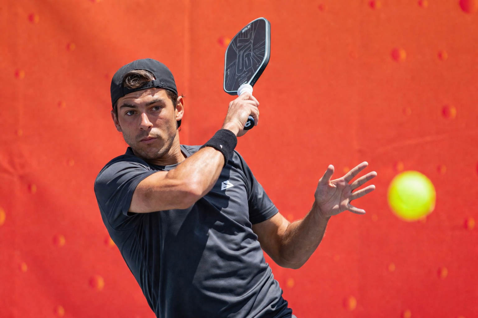 A pickleball player reaching low for a ball